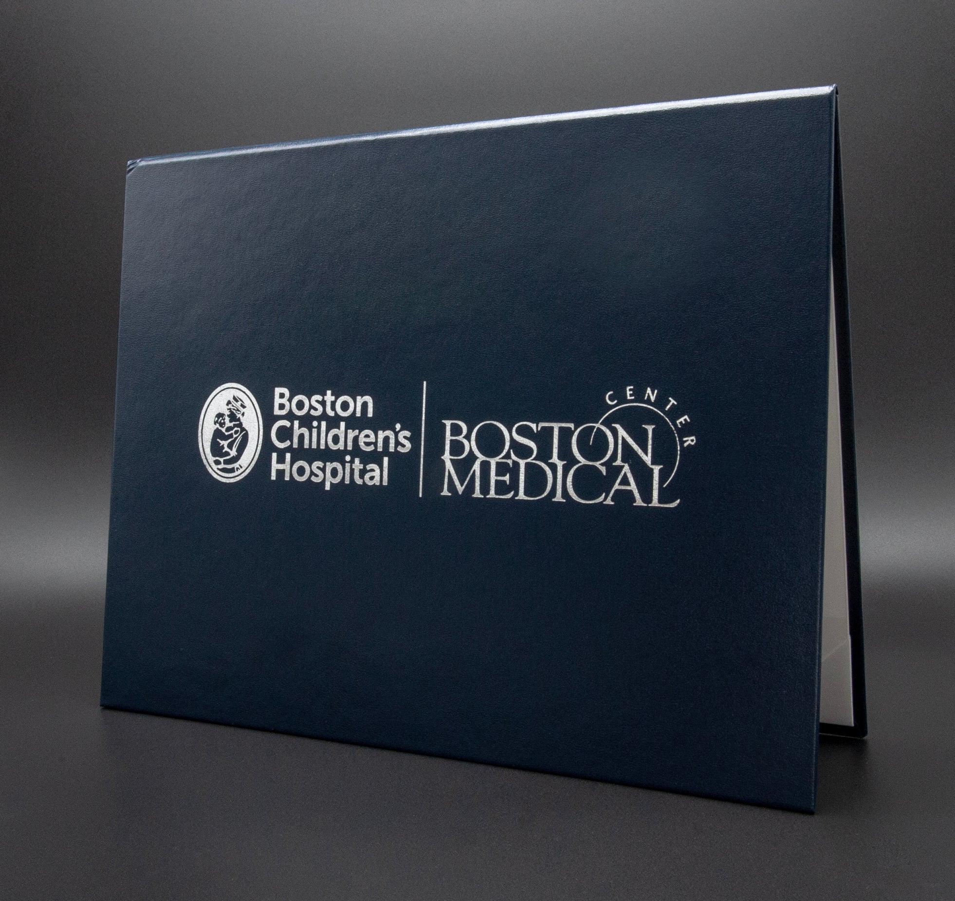 Dark blue folder with Boston Children's Hospital and Boston Medical Center logos on a gray background