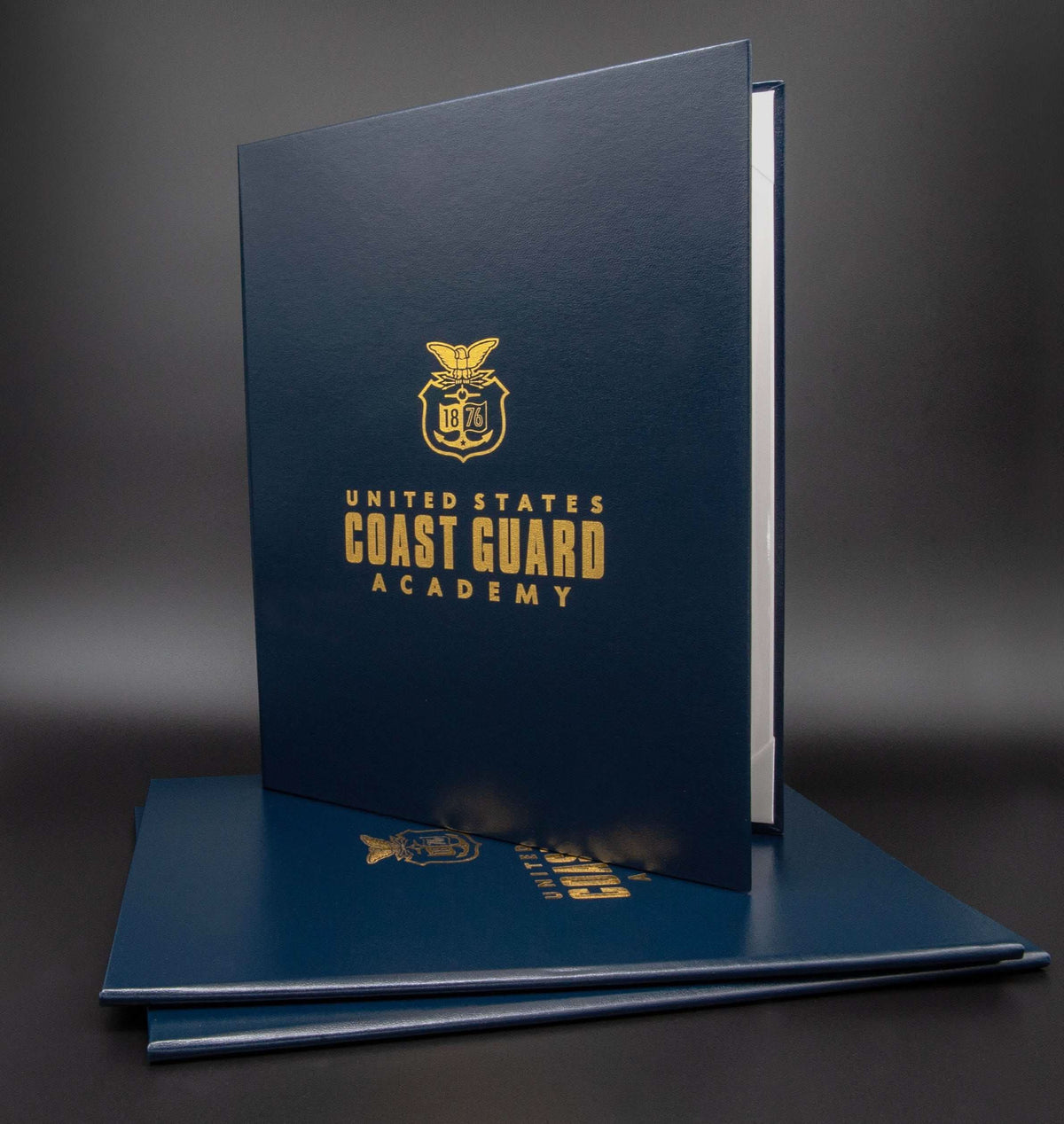 Custom tent-style document cover by Honor U featuring metallic foil logo and text, with US Coast Guard Academy branding.